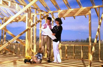 Photo of Couple looking at set of plans in their framed home