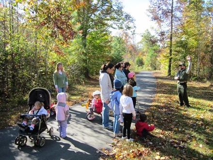 Children and parents playing in the leaves in fall